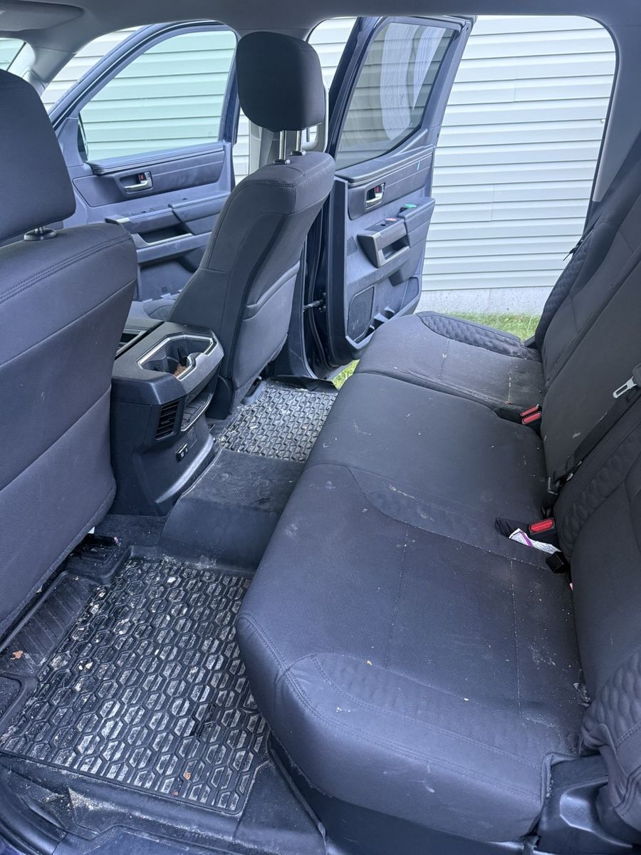 Before: rear bench seat of a pickup truck covered in crumbs and debris, with dirty floor mats
